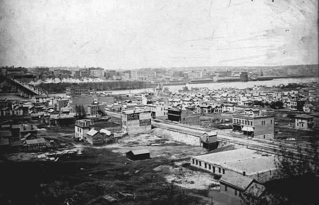 Black and white photograph of the lower West Side and Wabasha Bridge, c.1885. 