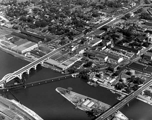 Black and white aerial view of the Flats, 1953, showing Robert, Wabasha, and railroad bridges and American Hoist and Derrick facilities.