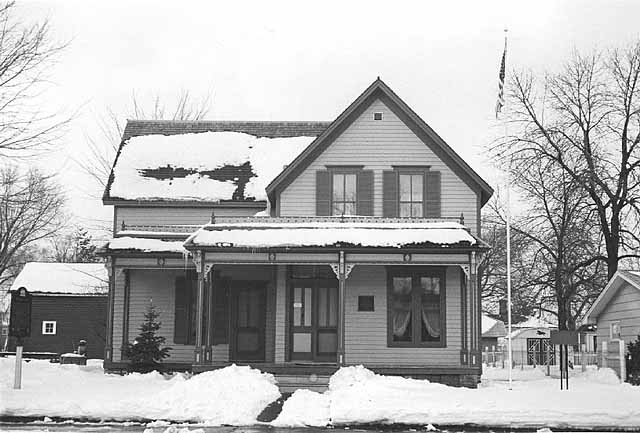 Black and white photograph of Sinclair Lewis’ childhood home, December 1975. Photographed by Henry Harren.