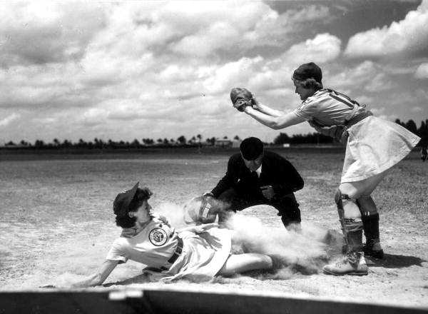 All American Girls Professional Baseball League player Marg Callaghan sliding into home plate as umpire Norris Ward watches (Opalocka, Florida)