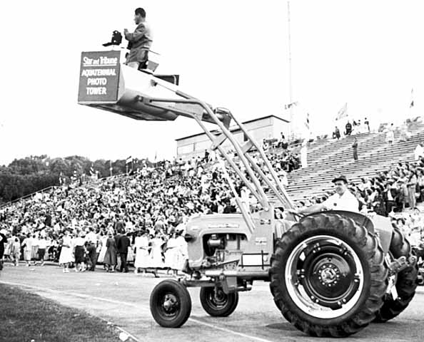 Black and white photograph of filming an Aquatennial event at Parade Stadium, August 10, 1956.