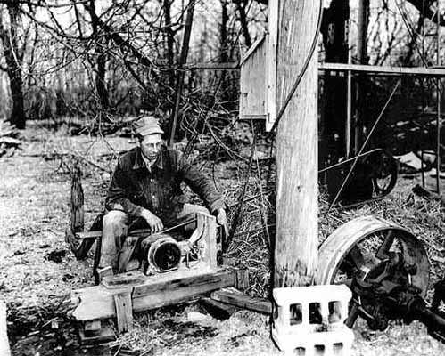 Black and white photograph of W. A. Benitt with electric pump at the windmill, 1938.