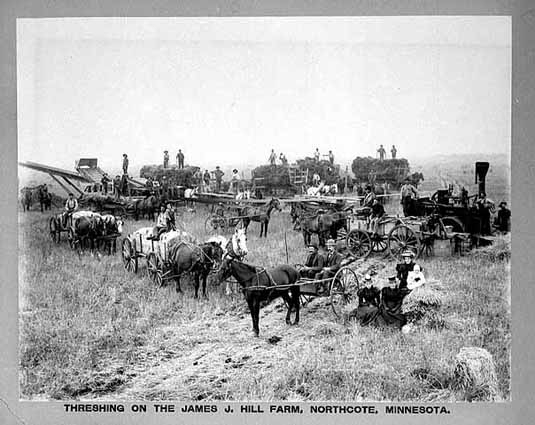 Black and white photograph of workers threshing on the James J. Hill farm, Northcote, c.1900. Photograph by A.H. Anderson.