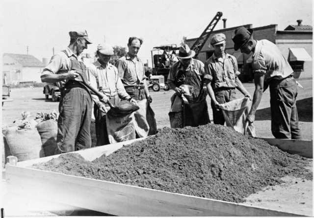 Black and white photograph of WPA crew mixing grasshopper bait for distribution to farmers, State Highway Maintenance Shops at Hopkins, 1937. 