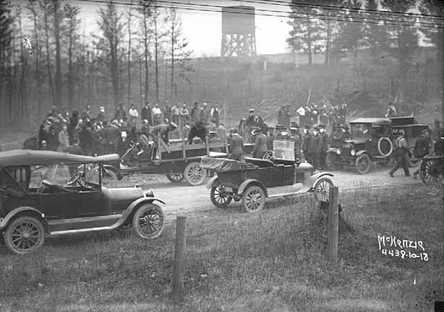 Black and white photograph of relief workers unloading coffins from Motor Corps vehicles after the fires of 1918.