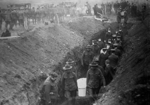 Black and white photograph of Minnesota Home Guardsmen burying dead of the Fires of 1918.