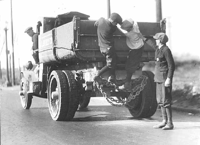 School Police gives warning to boys trying to hitch a ride on a truck.