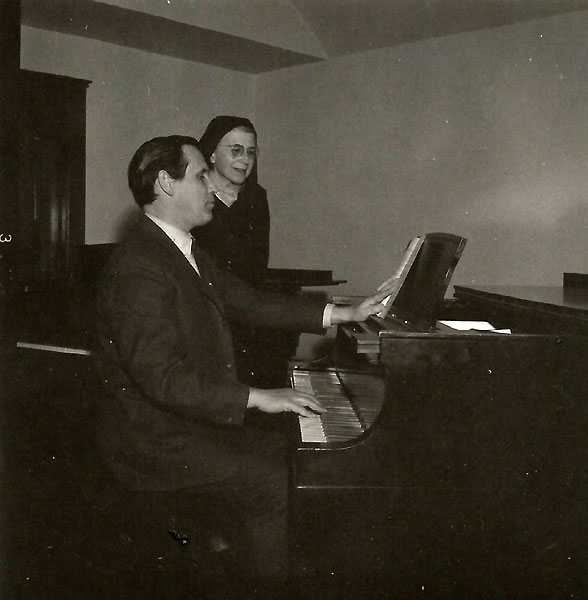 Black and white photograph of composer Paul Fetler (at the piano) with Alice Gustava Smith (Sister Maris Stella), c.1969.