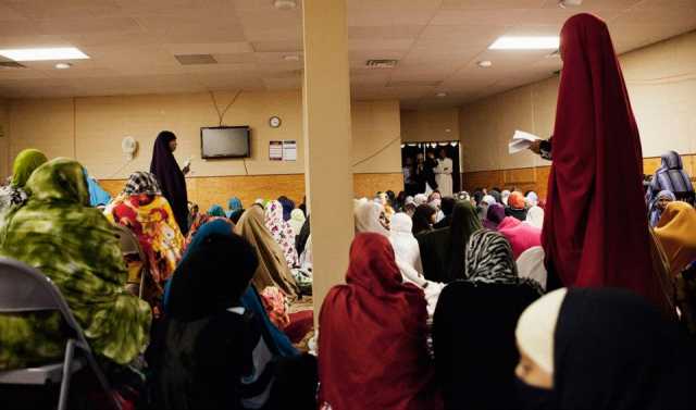 Color image of Somali women pray in the women’s prayer room at Dar Al-Hijrah during the holy month of Ramadan, 2013. 