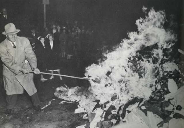 Governor Luther Youngdahl setting fire to restraints at Anoka County Hospital, October 31, 1949. Photograph by Hi Paul. Published in the St. Paul Pioneer Press on November 1, 1949, with the article, “Halloween Fire Heralds Reform—Anoka State Hospital Burns Straitjackets.” Original caption: “A flaming pile of strait jackets, manacles, and straps marked the end of the use of restraints at the Anoka State Hospital Monday night. Gov. Youngdahl, the moving force behind Minnesota’s mental health program, is sho