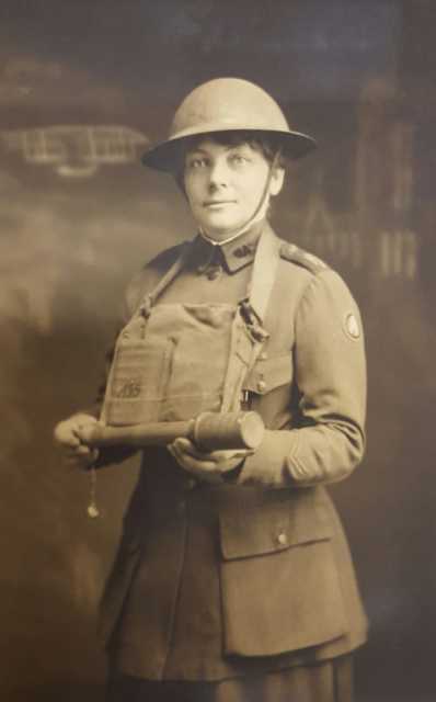 Black and white photograph of YMCA worker Julia Swenson holding a grenade, ca. 1919. Photographer unknown.