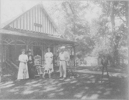 Photograph of four people in front of Villa Marie in Waconia. From left to right: Mrs. Emile Amblard; her mother, Mrs. Wood; Lillian Osterfelt; Mr. Emile Amblard. 