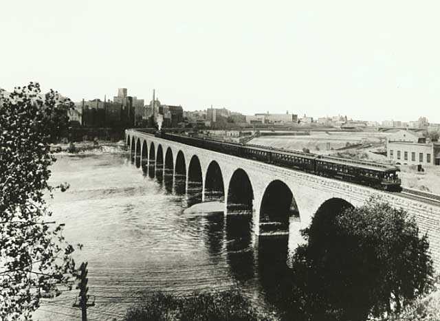 Train on the Stone Arch Bridge crossing the Mississippi River, Minneapolis; mill