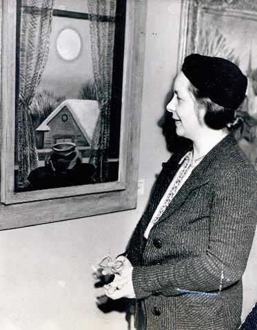 Black and white photograph of Elsa Laubach Jemne viewing Clement Haupers’ oil painting "Early Moon" in St. Paul, 1938.