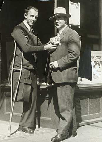 Black and white photograph of Congressman Melvin Maas (right) with a disabled constituent, 1930. 