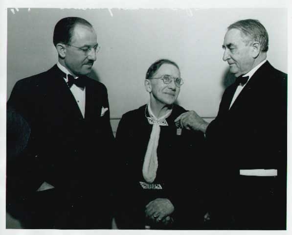 Black and white photograph of Theresa Ericksen (center) receiving a service medal on November 14, 1936.