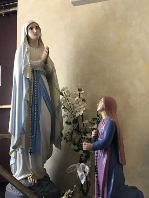 Color image of Sculptures of the Virgin Mary (at left) and Saint Bernadette (Bernadette Soubirous, at right). Interior of Our Lady of Lourdes Church, 27 Prince Street, Minneapolis, 2017. Photograph by Courtney Gregar.  