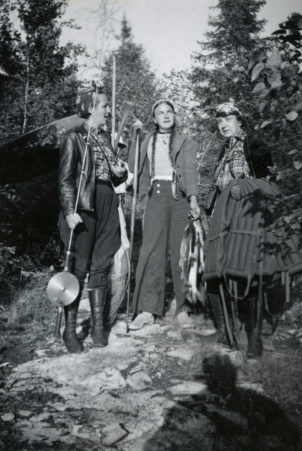 Black and white photograph of Dorothy Molter, Jule, and Verena at Bearskin Portage in the Boundary Waters Canoe Area Wilderness, ca. 1960s.