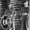 Black and white photograph of Martin Carlsted turning the handle of a manual corn sheller to remove kernels, c.1910.