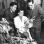 Black and white photograph of Entomology professor Henry C. Chiang (left) inspecting corn stalks for signs of corn borers with F. G. Holdaway and Jeanne Marie Hellberg, 1951.