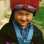 Color image of a Hmong American boy in traditional clothing. Photographed by Vue Xiong, c.1992.
