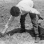 Black and white photograph of a Mexican American migrant farm worker harvesting asparagus near Owatonna, ca. 1955.