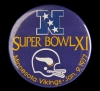 Color image of a plastic pin-back button commemorating the participation of the Minnesota Vikings in Super Bowl XI, played against the Oakland Raiders in Pasadena, California, 1977. The Raiders defeated the Vikings 32–14.