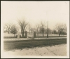 The stone fence added to the Woodbury House property by the Caswell family in 1911. Both the vehicle and pedestrian gates are visible, opening onto an unpaved Ferry Street. Photographer and exact date unknown. Anoka County Historical Society, Object ID# 2074.1.5. Used with the permission of Anoka County Historical Society.