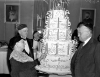 Black and white photograph of congregants lighting candles on a cake at the fiftieth anniversary celebration for Kenesseth Israel Synagogue in Minneapolis, c.1935.