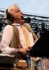 Sound effects artist Fred Newman creates sound with his mouth and other everyday objects during a live broadcast of A Prairie Home Companion from Macalester College in St. Paul, July 2015. Photograph by Wikimedia Commons user Jonathunder.