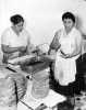 Black and white photograph of Mrs. Julio Lopez and Mrs. Francisco Rangle prepare food for an Mexican Independence celebration, Our Lady of Guadaloupe Church, September 15, 1958.
