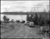 A view of cars, visitors, and Gunflint Lake at Gunflint Lodge. Photograph by Kenneth Melvin Wright, ca. 1950.