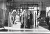 Black and white photograph of Assistant keeper Tom Hassing standing next to diesel air compressors at Split Rock Lighthouse c.1945.