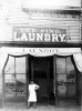 Yee Sing Woo standing in front of Yee Sing Laundry, 1319 Nicollet, Minneapolis