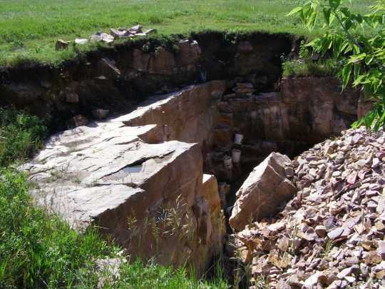 Color image of a pipe quarry pit, Pipestone National Monument, 2009. Photograph by the National Park Service.