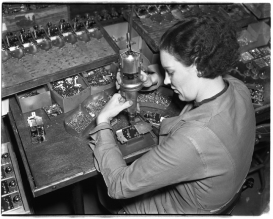 Woman operating a drill press