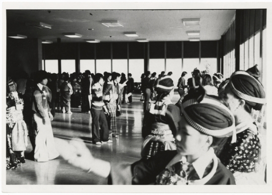 Black and white photograph of ttendees at the 1981 Hmong New Year, held in St. Paul’s Highland Junior-Senior High School, participate in pov pob, a ball-toss courtship ritual. Photographed by Marlin Heise on December 19, 1981.