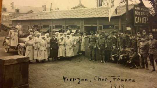 Black and white group photograph taken outside a Red Cross hut by Red Cross worker Julia Gray, 1919. 