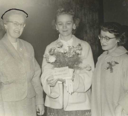 Black and white photograph of Doris Matzke being presented with a bouquet at a Crookston BPW club breakfast, September 22, 1957.
