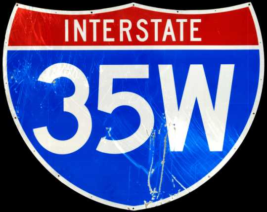 Highway identification sign for Interstate 35W. The sign stood on Bridge 9340, which carried I-35W over the Mississippi River in Minneapolis. The sign stood on the bridge at the time of its collapse on August 1, 2007. Its surface is heavily scratched, and this damage may be a direct result of the collapse.