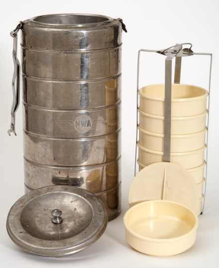 Color image of an insulated canister used to keep food warm in airline meal service. The canister, which contains eight plastic bowls, was used by Northwest Airlines, c.1950s.
