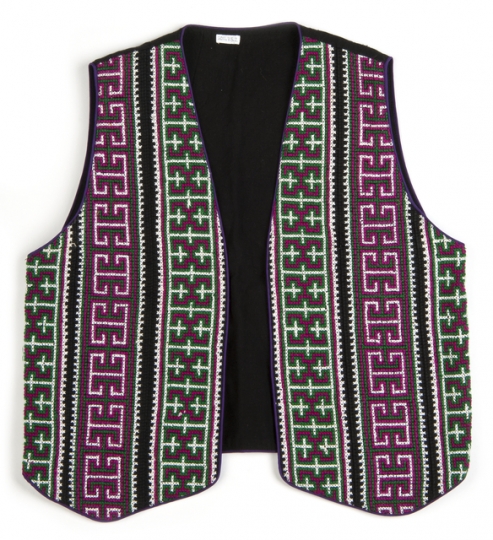 Color image of a reversible cotton vest with front panels of geometric cross-stitching made by a Minnesotan Hmong woman and sold by the Southeast Asian Ministry. Worn by Bea Vue-Benson, c.1999.