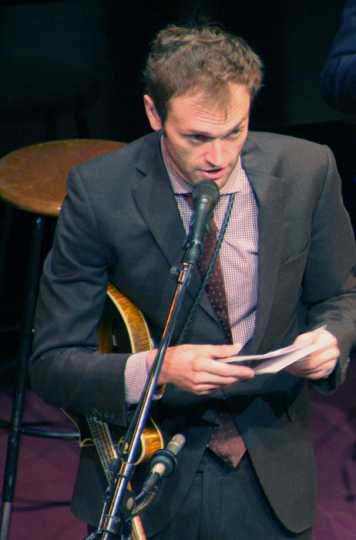 Prairie Home Companion host Chris Thile reads audience greetings during a broadcast at the Fitzgerald Theater in January 2016. Photograph by Wikimedia Commons user Jonathunder.