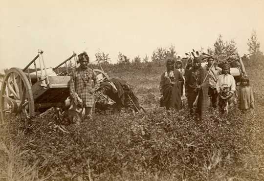 Black and white photograph of Ojibwe with Red River carts near Fort Dufferin, Manitoba, Canada, 