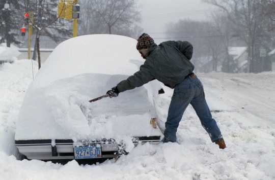 Color image of a resident of Minneapolis digging a car out of the snow after the Halloween Blizzard, 1991. Photograph by Rita Reed, Minneapolis Star Tribune.