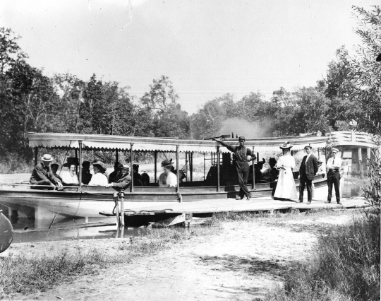 photograph of steamboat at a dock surrounded by passengers