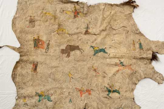Buffalo robe painted with human figures, horses, and buffalo. Made by Dakota during the late nineteenth century.