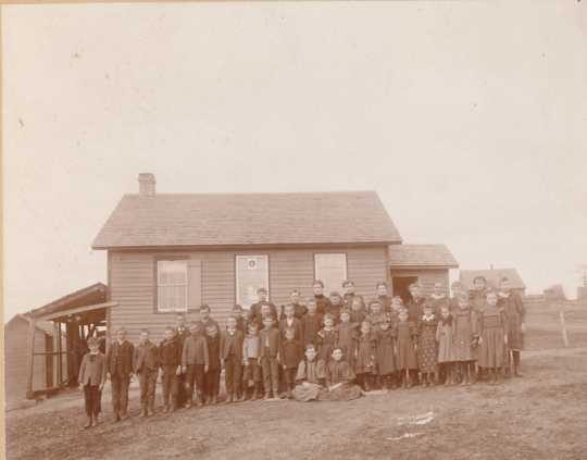 Photograph of Zoar public school (District #20) c.1895. Teacher Vena Abbott stands with her students outside the school building. Photograph Collection, Carver County Historical Society, Waconia.