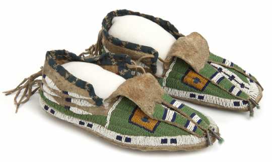 Pair of sinew-sewn leather moccasins with a rawhide sole. Made by Dakota Indians in the late nineteenth or early twentieth century.
