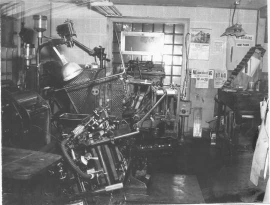 Black and white photograph of a printing machine in the office of the Waconia Patriot. Date and photographer unknown.